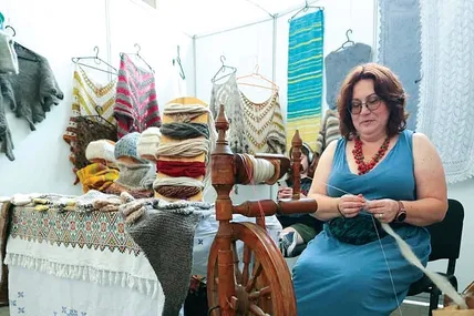 Працює умілиця на своїй улюбленій механічній прялці. Фото Львівської ОВА.
