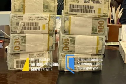 Пачки доларів, які вилучено у корупціонерів. Маркування показує, що їх привезли офіційно із банків США