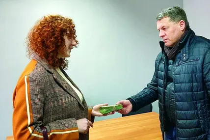 Внучка Дарина передає Роману Сущенку “ничку” від діда Бориса.