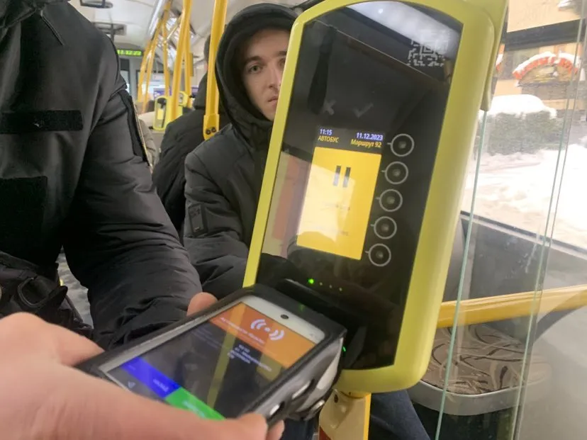 Контролер зчитує інформацію з валідатора автобуса.
