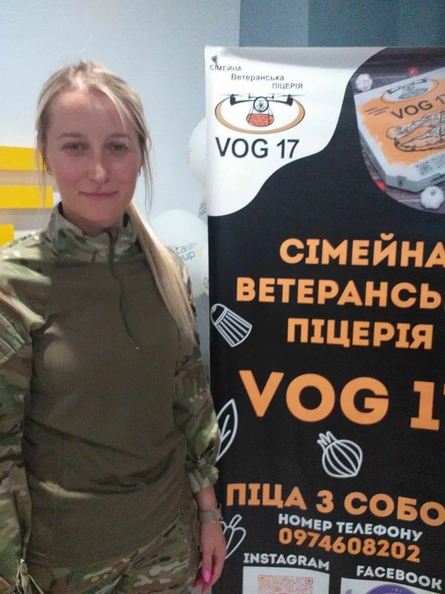 Ветеранка Уляна Кузик з банером сімейної піцерії VOG 17.