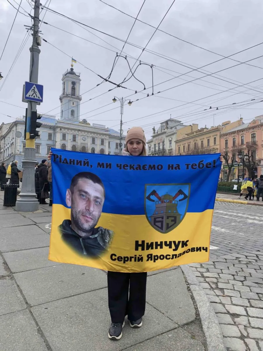Ольга також брала участь у подібній акції у Чернівцях. На прапорі напис: "Рідний, ми чекаємо на тебе!".