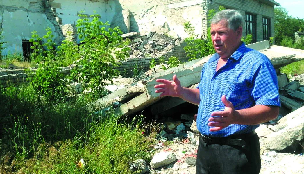 Володимир Черкасс показує руїни, які залишилися від прямого влучання снаряда. "Раніше там були спортзал та їдальня"