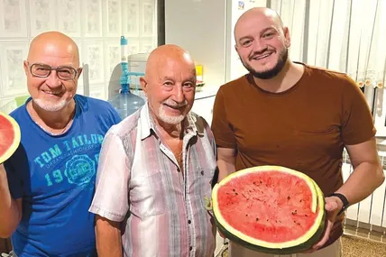 Леонід Улич (у центрі) пригощає родичів власноруч вирощеними кавунами. Фото з приватного архіву Леоніда Улича.