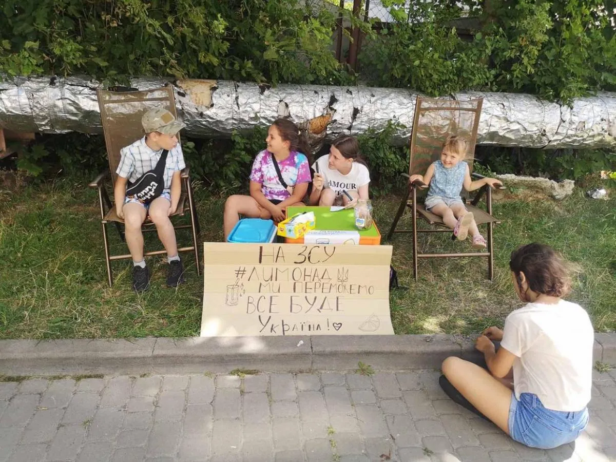 Сашко (ліворуч) щось розповідає дівчатам.
