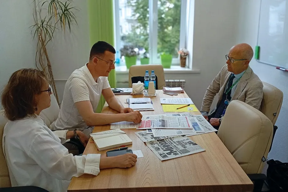 Посол Данії Оле Егберг Міккельсен (справа) слухає розповідь про нелегку роботу українських журналістів в умовах війни. Фото НСЖУ