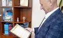 Суддя Плотніцький тримає в кабінеті три томи творів митрополита Шептицького: це презент від Садового